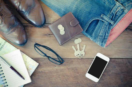 accessories jeans smart devices earphones hat glasses on a wooden floor.