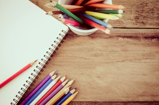 Color pencil and sketchbook on wood table