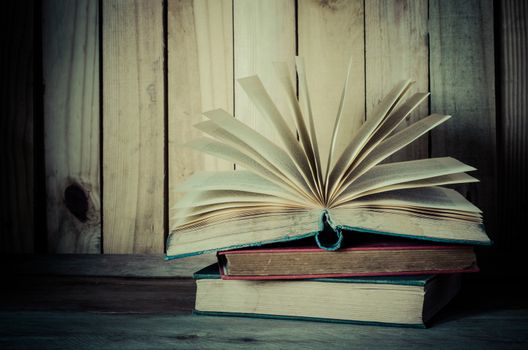 Old book open on a wooden floor - tone vintage