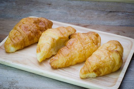 Croissants on plate on wooden table