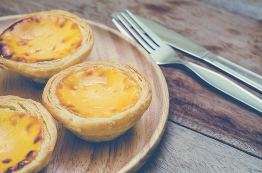 Egg tarts on a wooden plate