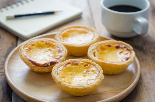 egg tart coffee notebook and pencil on the wooden table - tone vintage