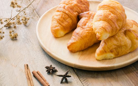 Croissants on plate on wooden table