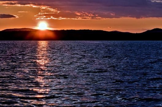 Golden sun sinks over the lake in the evening, golden water, South Ural lake Uvildy