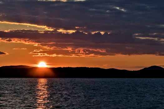 Golden sun sinks over the lake in the evening, golden water, South Ural lake Uvildy