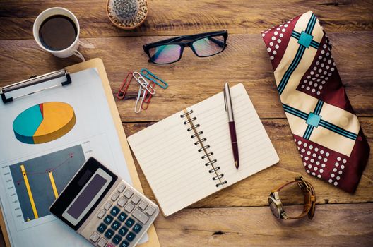 costume calculator, pen, notebook and accessory for work on wooden table.