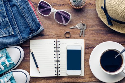 top view image of smartphone with blank screen headphones coffee cup and costome on wooden floor