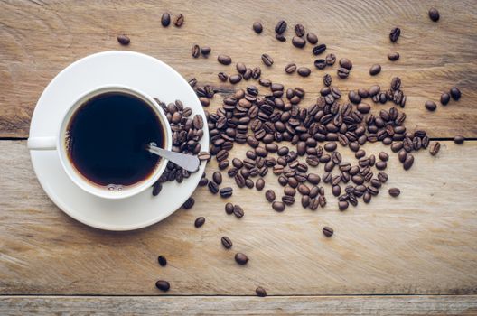 Coffee cup and beans coffee on a wood background.