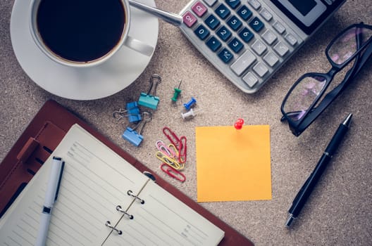 Note placed on the table and a cup of coffee office supplies on the table.