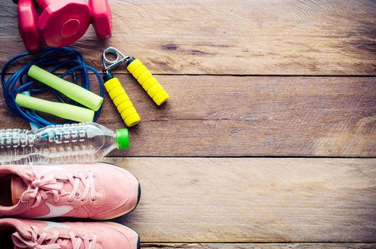 fitness concept with Exercise Equipment on wooden background.