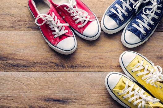 Multicolored sneakers on wooden floor