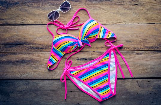 Beauty colorful bikini on wooden floor