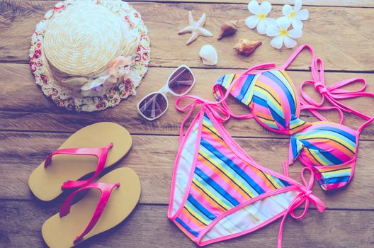 Beauty colorful bikini and accessories on wooden floor