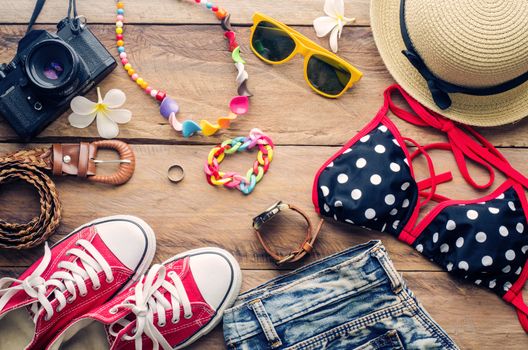 Beauty colorful bikini and accessories on wooden floor