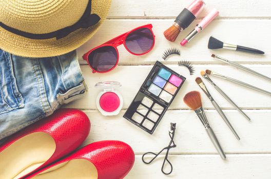 Cosmetics and apparel for women on the white wooden floor