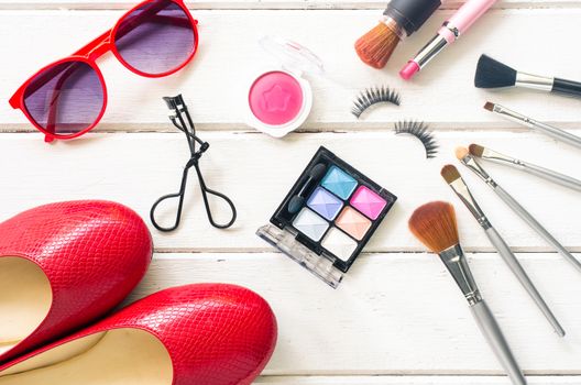 Cosmetics and apparel for women on the white wooden floor
