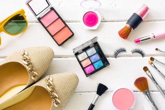 Cosmetics and apparel for women on the white wooden floor