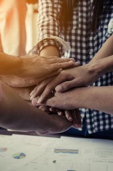 Concept of teamwork: Close-Up of hands business team showing unity with putting their hands together.