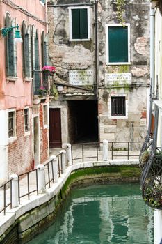 - channel in Venice with beautiful buildings reflecting in water