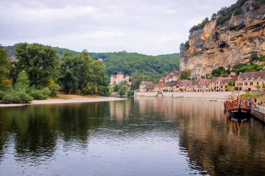  The picturesque medieval village of La Roque Gageac nestled in the cliff and reflecting in Dordogne river