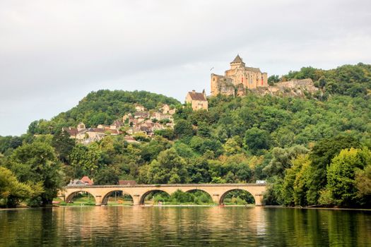 landscape of river dordogne with a bridge and the castle of castelnaid on the cliff