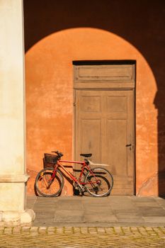 AT BOLOGNA - ITALY - ON 03/24/ 2013 - red bycicle on an old  yellow wall in Bologna, Italy 