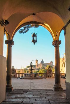 courtyard of rinascimental  town hall of Viterbo with a fountain and landscape of city center on background