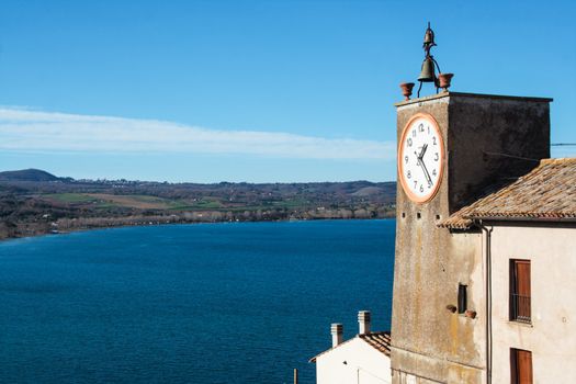 view of Bolsena lake from the fortress of Capodimonte with clock tower watching the lake , Capodimonte, Viterbo, Lazio, Italy