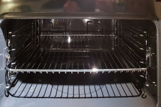 A view of the cross section of an open empty household stove from the inside, the view from the direction of the open door.

