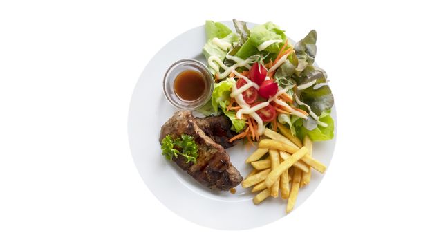 Grilled steak with french fries and fresh vegetables on white plate