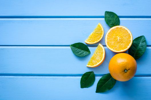 Fresh oranges and juice on the blue wood 