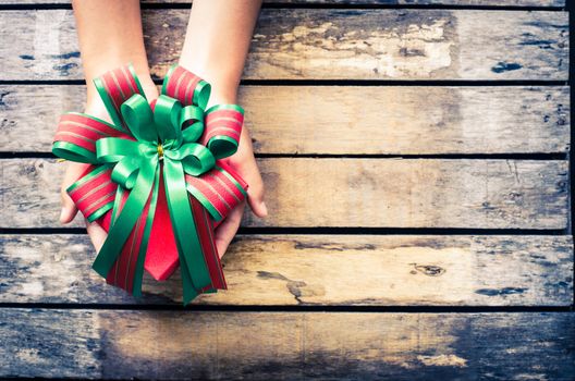 hands holding gift on wooden table.