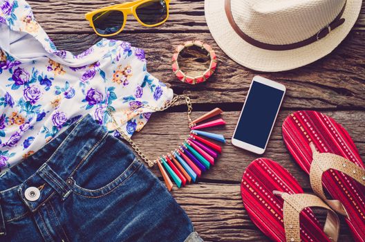 Clothing and accessories for women on wood floor for travel at holiday