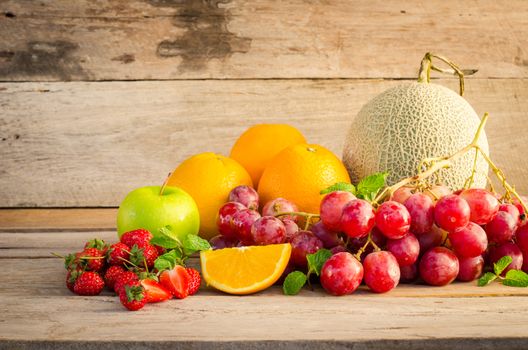 Many types of fruit placed on a wooden floor.