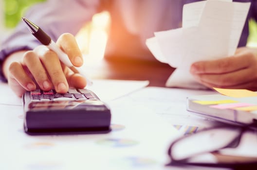 Businessman are working with a calculator and laptop. in office business concept 