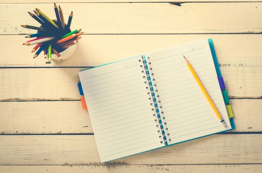 Color pencil and notebook on wood table rough