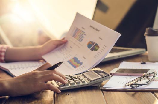 Businessman holding paperwork on the table and analyzing investment chart working in office. Business work concept