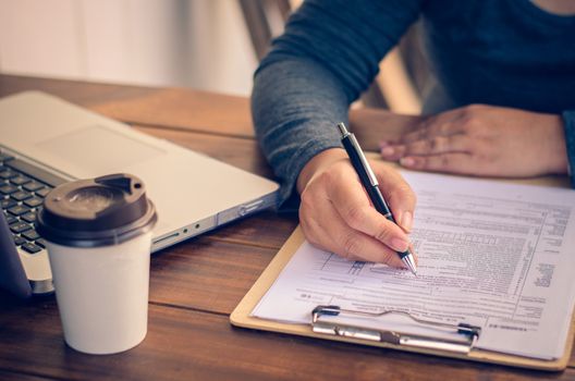 Businessman holding paperwork on the table and analyzing investment chart working in office. Business work concept. 