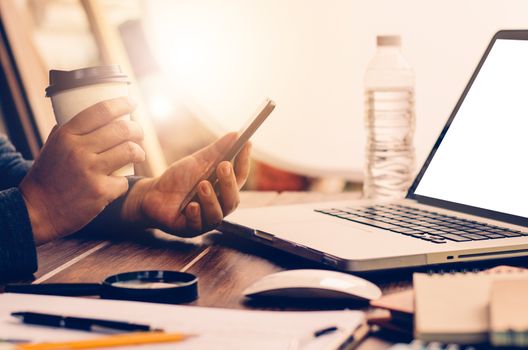 businessman holding smartphone and a cup of coffee break