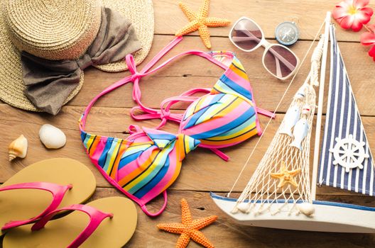 Beauty colorful bikini and accessories on wooden floor for trip on summer 