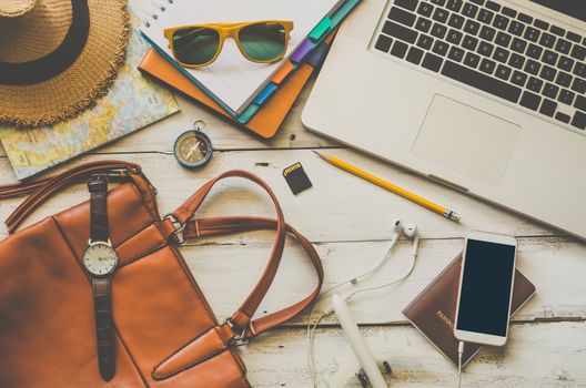 Laptop and travel accessories costumes Tourism planning and equipment needed for the trip on wooden floor