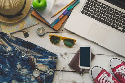 Laptop and travel accessories costumes Tourism planning and equipment needed for the trip on wooden floor