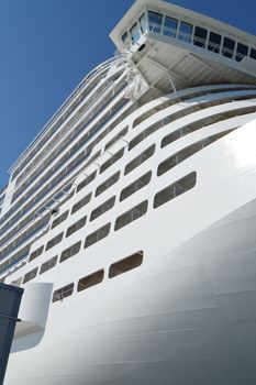 Luxury white cruise ship on blue sky background close-up.