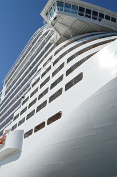 Luxury white cruise ship on blue sky background close-up.