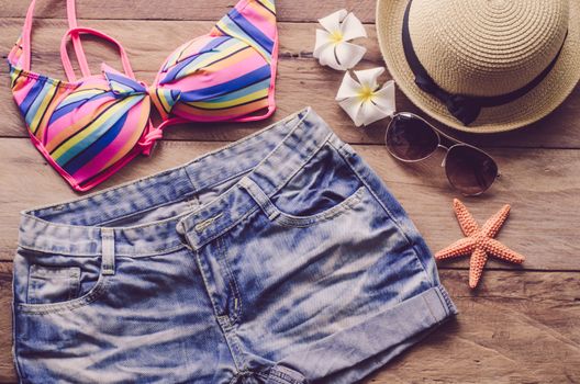 Beauty colorful bikini and accessories on wooden floor for trip on summer 