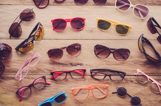 Many sunglasses fashion and eyeglasses on the wood