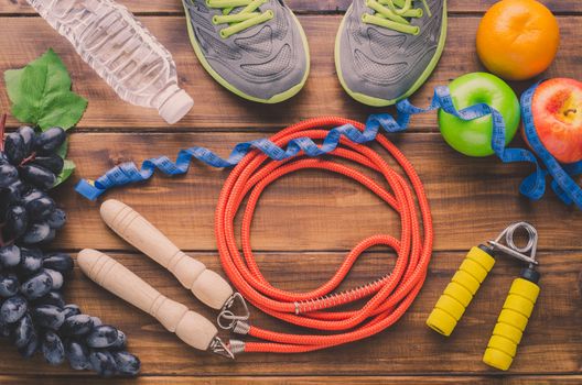 fitness concept with Exercise Equipment on wooden background.