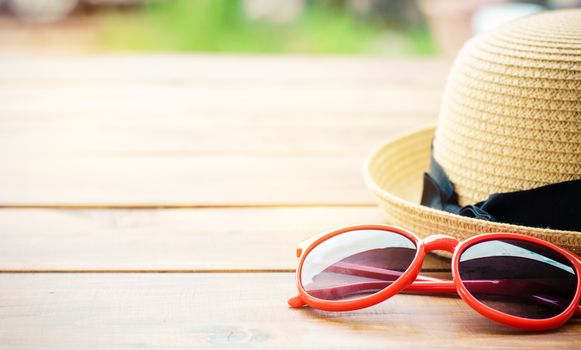 Hat and red sunglasses fashion on the wood