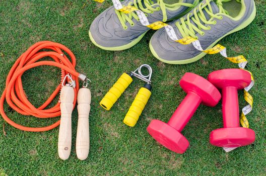 fitness concept with Exercise Equipment on green grass background.