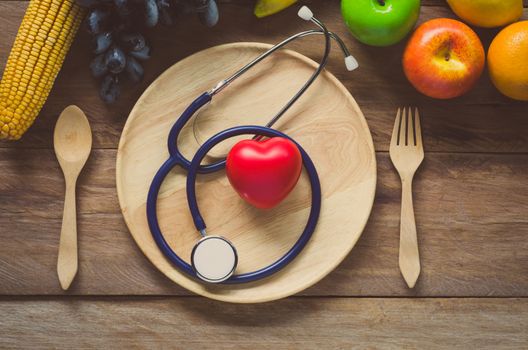 Healthy concept, fruit and ear doctor on wood background